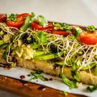 Avocado, artichoke hearts, kalamata olives, clover sprouts, tomatoes, cherry peppers, roasted garlic, cilantro, olive oil at Journey Cafe in Kailua Kona