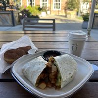 Vegan breakfast burrito and oat milk cappuccino. (The cinnamon twist in the bag is from another vendor nearby in the Hall).   at Undercurrent Coffee - Optimist Hall in Charlotte