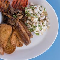 Vegan sausages, scrambled tofu, sautéed chestnut mushrooms, grilled tomato, house baked pinto beans, Maltese crust and EVOO at One80 in Mgarr