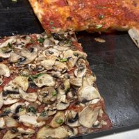 Another mushroom pizza with the spicy tomato sauce pizza in the back   at Alice in Lucca