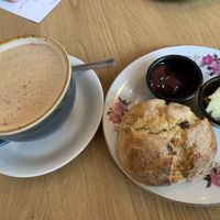 Decaf oat milk cappuccino and vegan scone with jam and butter  at Glass Onion in Liverpool