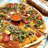 Vegan pizza: firm dough with vegan pesto, tofu, mushroom, cherry tomato, olive, oregano, arugula. at Garun in Yerevan