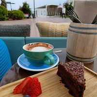 Chocolate cake and oatmilk cappuccino. Some fruit lifted along for vitamins. at Ve Cafe in Ibiza
