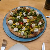 seasonal pizza with mango, avocado cream, fermented nut cheese, tomatoes, greens & Tajín Clásico seasoning at Blu Bar in Barcelona