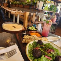 Mezze appetizer plate with espresso martini and blueberry n/a drink. Live plant decor in spacious layout. at Wildseed in San Francisco