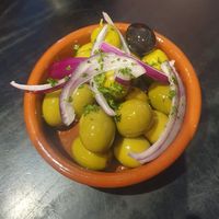 Starter: Dish of Marinated Olives - Green and black olives (with stone), marinated in olive oil, pink peppercorns, red onion and garlic at Giannis in Scarborough