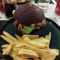 Burger con finto pollo, salsa al curry, salsa buns, insalata pomodoro. Accompagnato da patatine fritte at Buns in Alghero