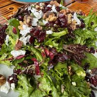 Vegan version of The Privateer Salad: Mixed greens, radicchio, spinach, Privateer vinaigrette, vegan cheese, candied walnuts, dried cranberries at The Privateer in Oceanside