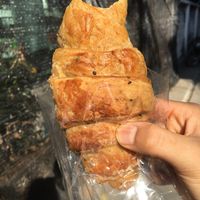 Whole-wheat croissant (with a sneaky bite out of it) at Da's Home Bakery in Chiang Mai