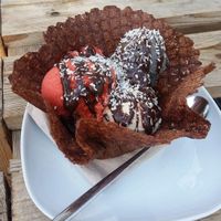 Vegan sundae with three flavours, chocolate cone, chocolate sauce and coconut flakes at Thommy's Eismanufaktur in Leipzig