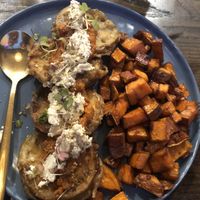 Gluten free vegan crispy eggplant : whipped almond ricotta , fire roasted red pepper and tomato , ajvar fresh basil and side of Caesar salad   at The Wild Feast Cafe in Rockville Centre