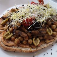 Biodesem-olijfbrood met zuiderse Cashewspread kikkererwten, aubergine, paprika, preischeuten en groene olijven at HART in Antwerpen