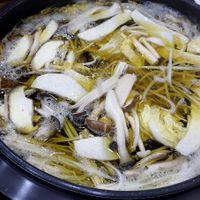 Pot with mushrooms and plant-based broth at Mushroom Shabu Shabu 버섯샤브샤브 in Seogwipo