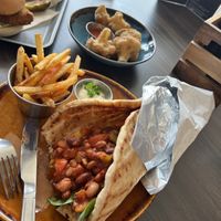 Greek pitta with 3 bean chilli, paprika fries, cauliflower fritters and ‘chicken’ burger.  at The Urban Fox in Leamington Spa