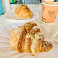 Almond Croissant in front and a Zaatar croissant at the back with a tasty almond milk café latte   at Toastic Bakery in Riyadh