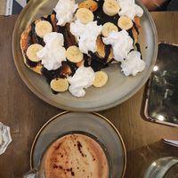 two pancakes with chocolate sauce, banana, and whipped cream and a hot chocolate. the hot chocolate had that distinctive "vegan chocolate" taste which i'm not personally a fan of at Vegivores in Reading
