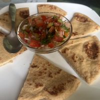 Hummus topped with salsa served with pita sliced  at Aum Cafe in Varanasi