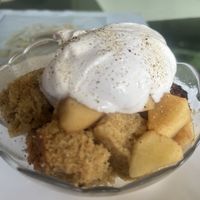 Spice cake with warmed apple cinnamon slices topped with vegan cream  at Aum Cafe in Varanasi