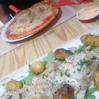 Seitan in a creamy sauce on a bed of rocket with crispy potatoes at Sora Lella Roman Vegan Restaurant in Edinburgh