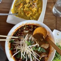 Vietnamese yellow curry and rice with crispy tofu on top, hot and spicy pho with vegan chickn on bottom  at Pho - Islington in North London