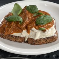 Toast with heirloom tomatoes, cashew creme, harissa, and basil  at Williams Eatery in Auckland