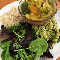 Curry acompañado de hojas verdes, arroz integral y fideos  at Nourish in Inverness