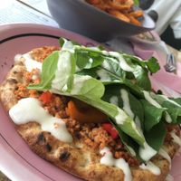Vegan pizza: flatbread with soya mince, mixed caramelized bell peppers, fresh rocket salad and vegan sour cream at Estrella in Paphos