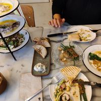 Hummus, baba ganoush and Lebanese salad (towered left) with the pita bread. Stuffed pita with dill mayo (center left), chili green beans (center) and broccolini's (right) at HUMM Restaurant in Antwerpen