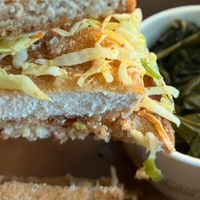 Vegan 'chicken' sandwich. sub multigrain bread toasted with collard greens at Busboys and Poets - Langston Lofts in Washington