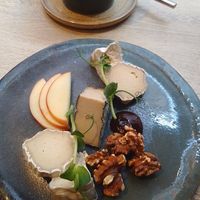 cheese board with bread, apple, walnuts, fig jam, blue, goat, and camembert at the friendly kitchen in Paris