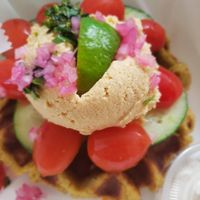 Falafel waffle with hummus, pickled onion relish, tomatoes and cucumbers and tahini dressing (on the side). Oh, so yummy delicious!! at Green Box Kitchen in Wilmington