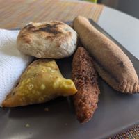 Left to right: Samosa, bake stuffed with split pea curry, accra (black eyed pea fritter), and sweet plantain encased in whole wheat. at StarLine Ital Kitchen in Roseau