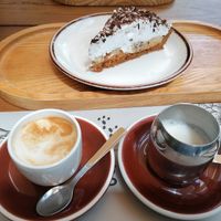 Cafe con bebida de avena y tarta con base de galleta, platano y nata at 7g Roaster in Vila Nova De Gaia