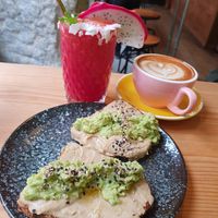 Pitaya smoothie, avocado toast and hummus. Latte at Frutas Prohibidas in Madrid