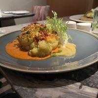 Cauliflower steak with turmeric, capers, sun blushed tomatoes, spring onions, vegan cheese, romesco sauce & celeriac puree  at Fellinis in Ambleside