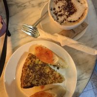 Leek quiche accompanied by some pesto bread (not ordered, but they always add it😄) and a cappuchino  at The Vegan Corner in Barcelona
