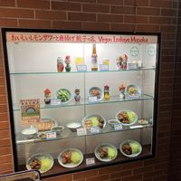 Window at front of store showing some menu options  at Izakaya Masaka in Tokyo