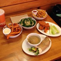 Sweetheart fries, kale salad, buffalo wings, Yukon fries, mini Mexi wrap, and mashed cauli-potatoes at Veggie Grill in West Hollywood