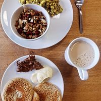 Tofu brouillé, granola, pâte à tartiner, beurre de pomme, pancakes et chaï latte at Comme une Poule in Toulouse