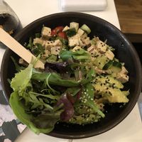 Build your own bowl with: sushi rice, tofu, cucumbers, cilantro, tomatoes, spring onions, crazy lime dressing & avocado. They put sesame seeds and arugula on all bowls.   at Ma'loa in Berlin