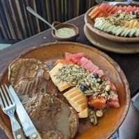 Pancakes (front) and fruit bowl. at Elela in Valladolid