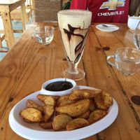 Potato wedges and delicious vegan cold coconut coffee  at Yogi's in Auroville