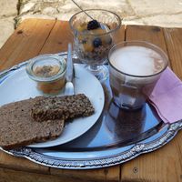 Wholemeal bread with carrot spread, overnight oats, and hot chocolate with oat milk at Palais Café in Dresden