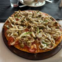 Undercooked custom vegan pizza with raw onions, mushrooms, peppers, olives on a regular crust dough 😟I got really sick that night   at Bliss in Freetown