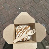 Cinnamon roll in cashew cream in a paper takeaway box   at It's a Trap in Dublin