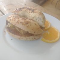 Tofu breakfast sandwich with vegan cheese, garlic spread on an onion bagel at Paradigm Coffee & Music in Sheboygan