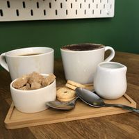 Americano with oat milk, oat milk cappuccino plus two mini biscuits   at Mr Cooper's Coffee House in Whitby