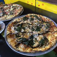 Eggplant, mushrooms, onion and spinach plus vegan cheese on my pizza. The other pizza has tomato, egglant, mushrooms and pineapple plus vegan cheese. Size is large.  at Minuteman Pizza in Uyuni
