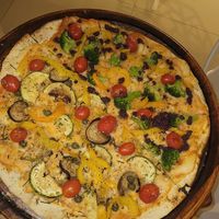 vegan pizza with cassava cheese, half broccoli and pesto, half vegetarian at Vinopizza in Praia Do Forte