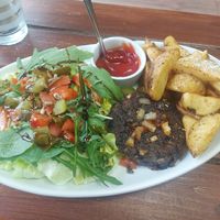 A black bean burger, chips & salad at Brasil Vegano Cafe in Guildford